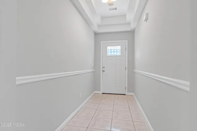 a view of a kitchen with refrigerator and white cabinets