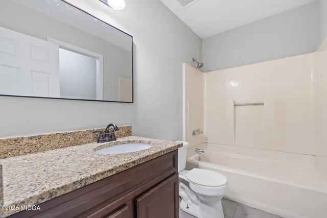 a front view of house with yard and tress in the background