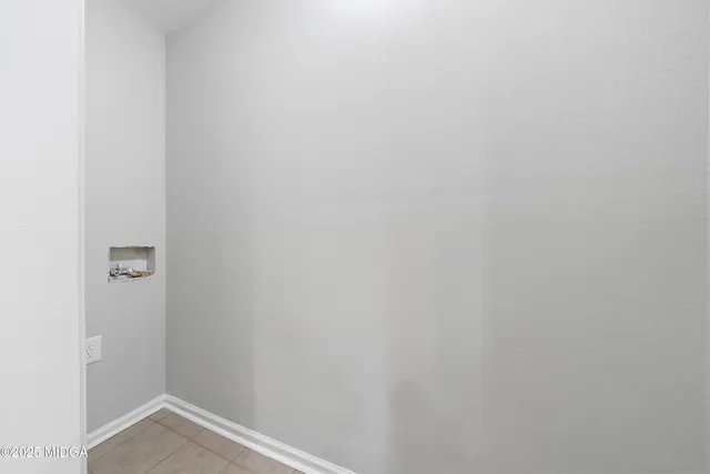 a front view of house with yard and trees in the background