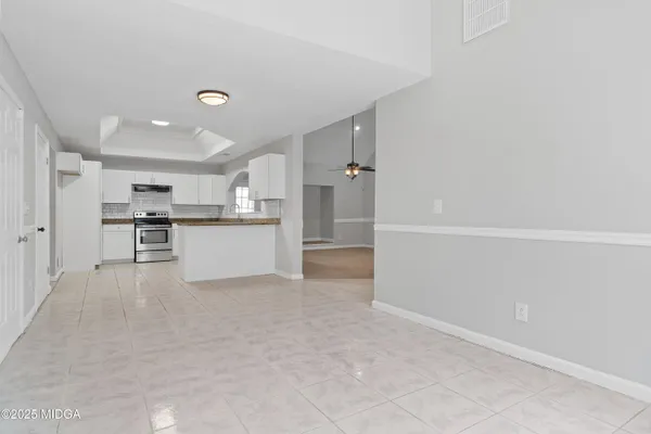 a kitchen with granite countertop white cabinets and white appliances