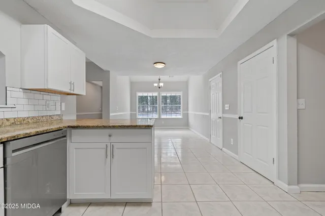 a bathroom with a granite countertop sink and white cabinets