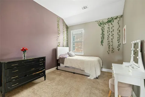 a spacious bedroom with a bed dresser and a window