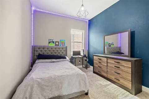 a bedroom with a bed and a dresser in it