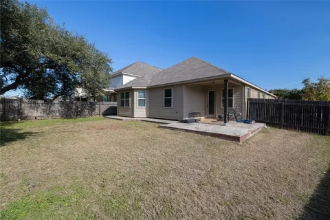 a view of a house with backyard and trees