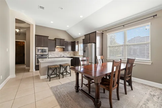 a view of a dining room with furniture and a kitchen
