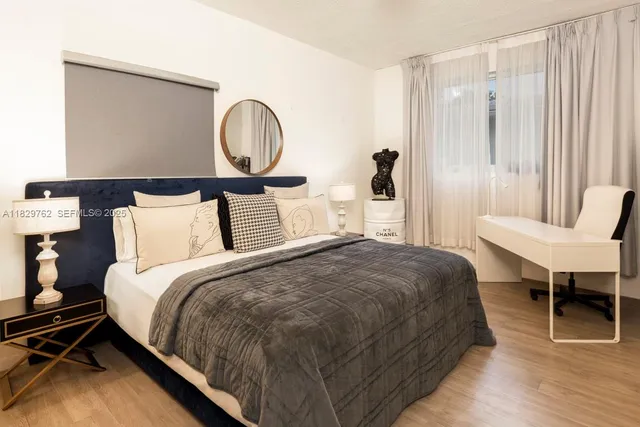 a spacious bedroom with a bed a table and a closet