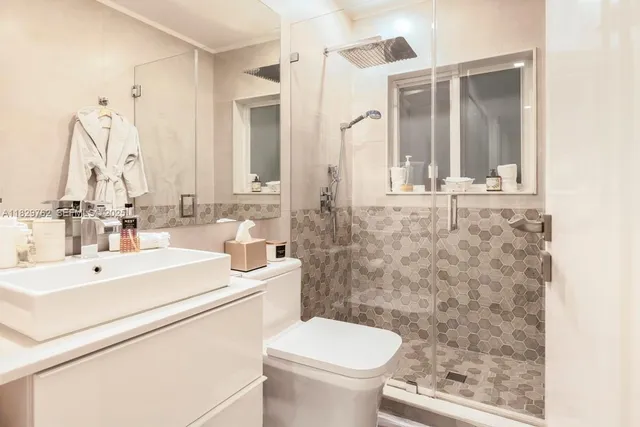 a bathroom with a sink a toilet and a mirror