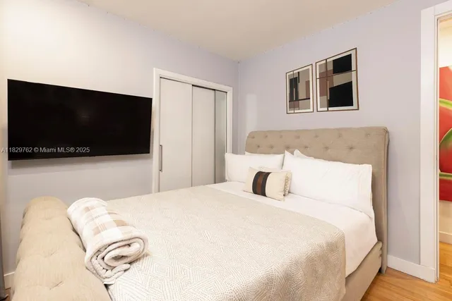 a bedroom with a bed and a flat screen tv