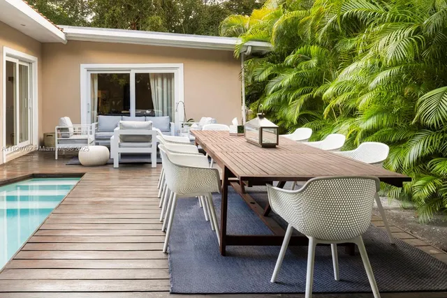 a view of a patio with table and chairs with wooden floor and plants
