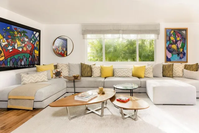 a living room with furniture a rug and a large window