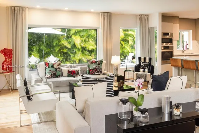 a living room with fireplace furniture and a large window