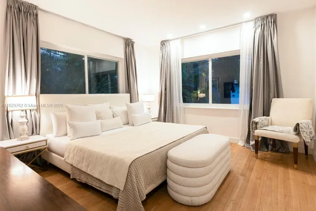 a bedroom with a bed and a large window