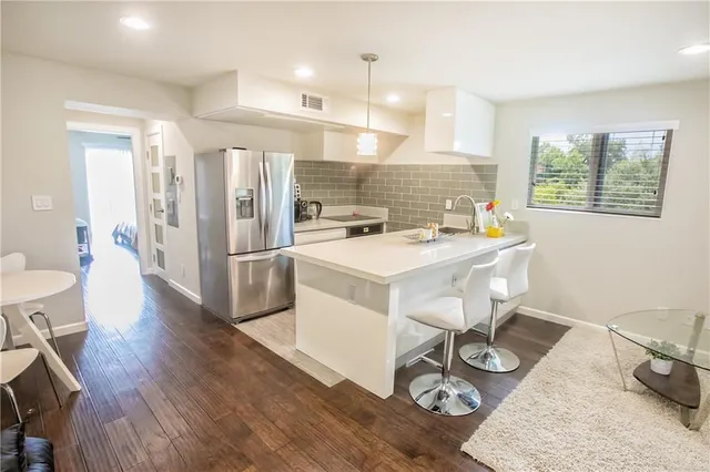 a kitchen with a sink a stove and wooden floor