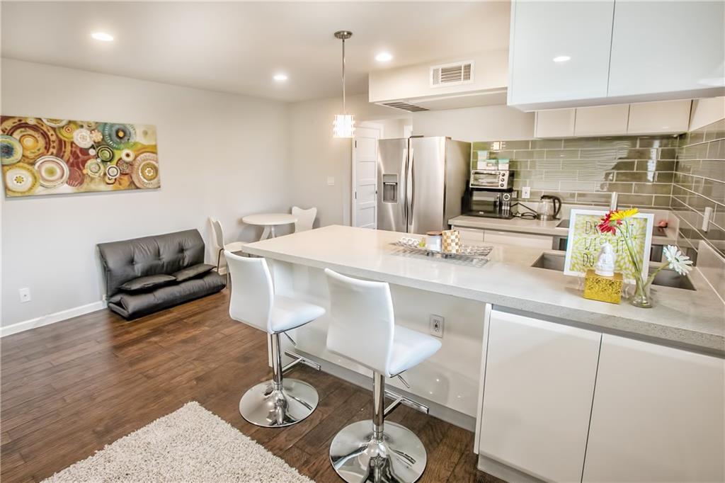 3110 Red River Street, Unit D315 Austin, TX 78705 - Photo 3 of 12 a kitchen with stainless steel appliances granite countertop a sink a stove a refrigerator cabinets and living room view