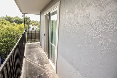 a view of a balcony with wooden floor and fence