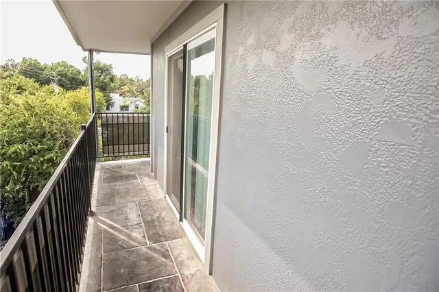 a view of a balcony with wooden floor and fence
