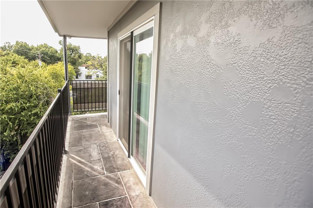 3110 Red River Street, Unit D315 Austin, TX 78705 - Photo 9 of 12 a view of a balcony with wooden floor and fence