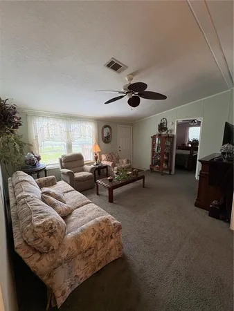 a living room with furniture a air conditioner vent and a window