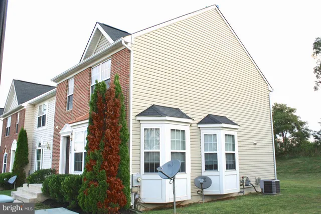 a view of a white house next to a yard