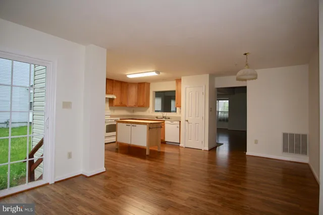 a view of a kitchen with wooden floor and a window