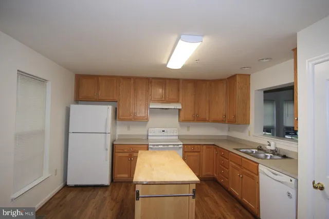 a kitchen with a refrigerator sink and cabinets