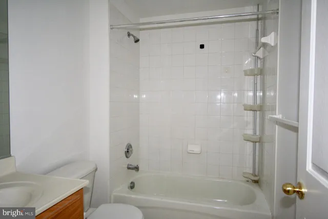 a bathroom with a granite countertop bathtub shower and toilet