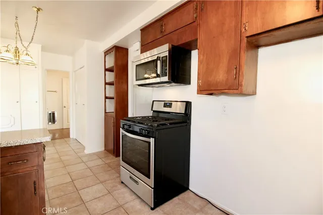 a kitchen with stainless steel appliances granite countertop a stove a microwave and a refrigerator