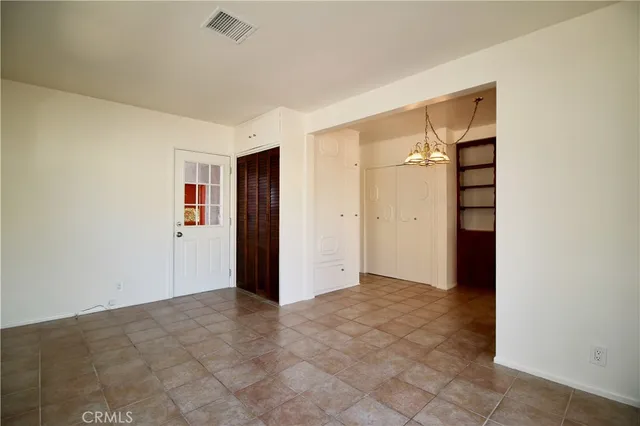 an empty room with closet and mirror