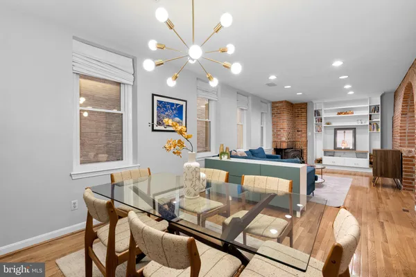 a view of a dining room with furniture a chandelier and wooden floor