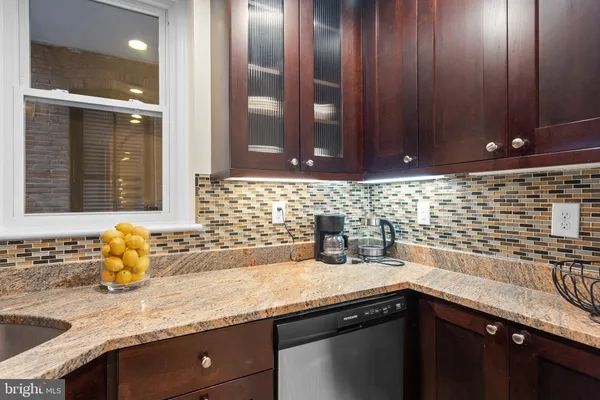 a kitchen with granite countertop a sink and cabinets