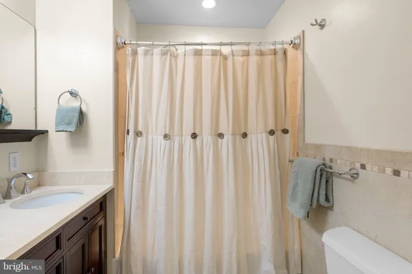a bathroom with a sink a toilet and shower curtain