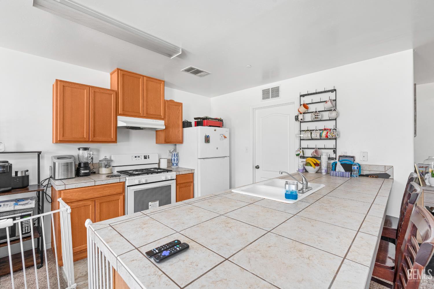 Undisclosed Address Bakersfield, CA 93306 - Photo 12 of 30 a kitchen with a sink a stove and white cabinets