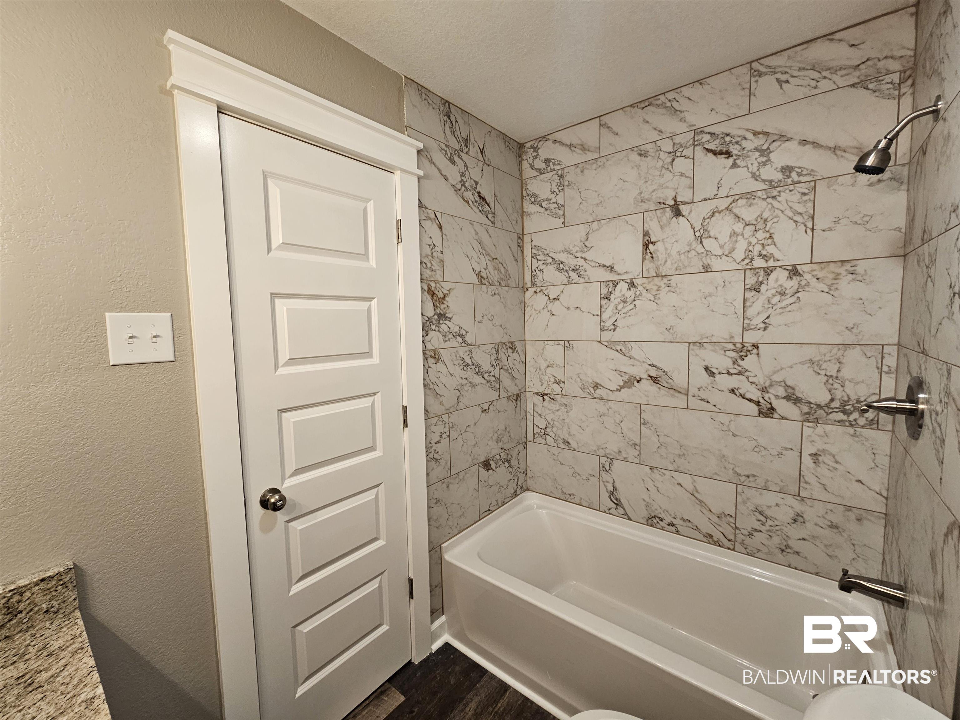 138 Wicker Way Daphne, AL 36526 - Photo 17 of 32 Bathroom with a textured wall, bathing tub / shower combination, and a textured ceiling