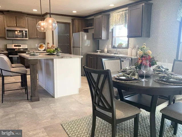 a kitchen with stainless steel appliances a dining table and chairs