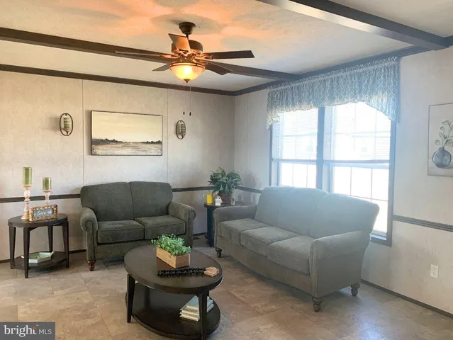 a living room with furniture a chandelier and a large window