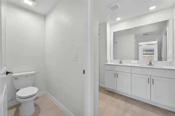 a bathroom with a toilet a sink and mirror