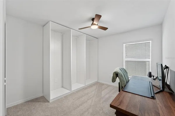 a view of a workspace with furniture and a window