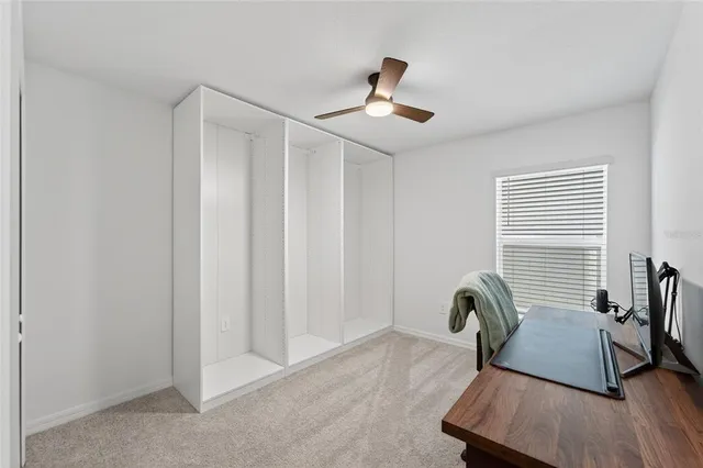 a view of a workspace with furniture and a window