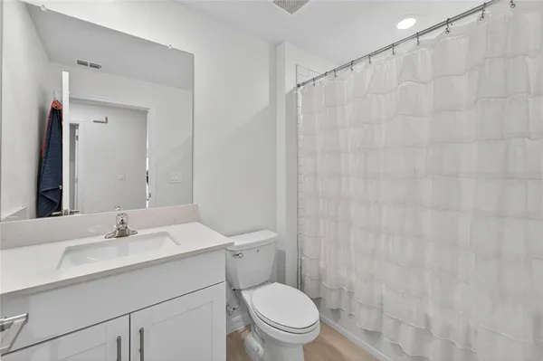a bathroom with a sink a toilet and shower curtain