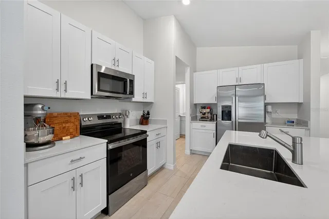 a kitchen with a sink a microwave and cabinets