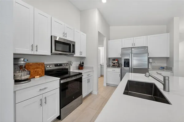 a kitchen with a sink a microwave and cabinets