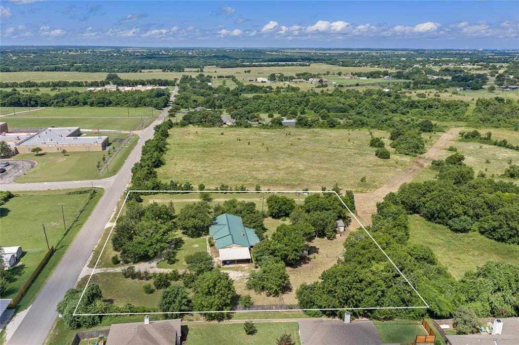 440 Williams Road Lorena, TX 76655 - Photo 3 of 19 Aerial view showcasing a residential property with a green metal roof, surrounded by mature trees