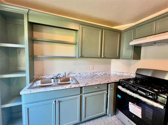 a kitchen with stainless steel appliances granite countertop a sink stove and cabinets