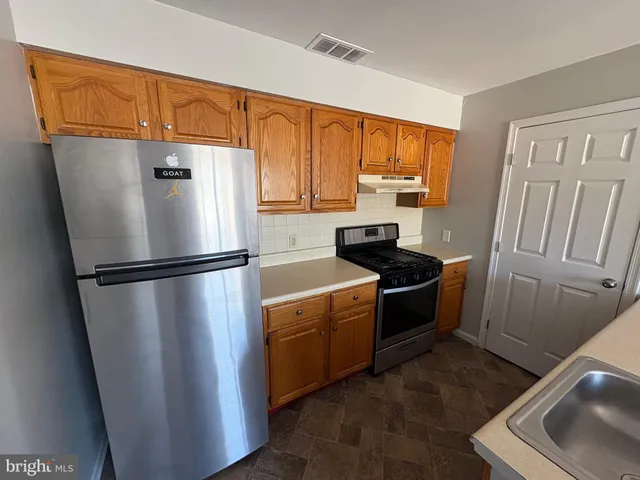 a kitchen with sink a window and wooden floor