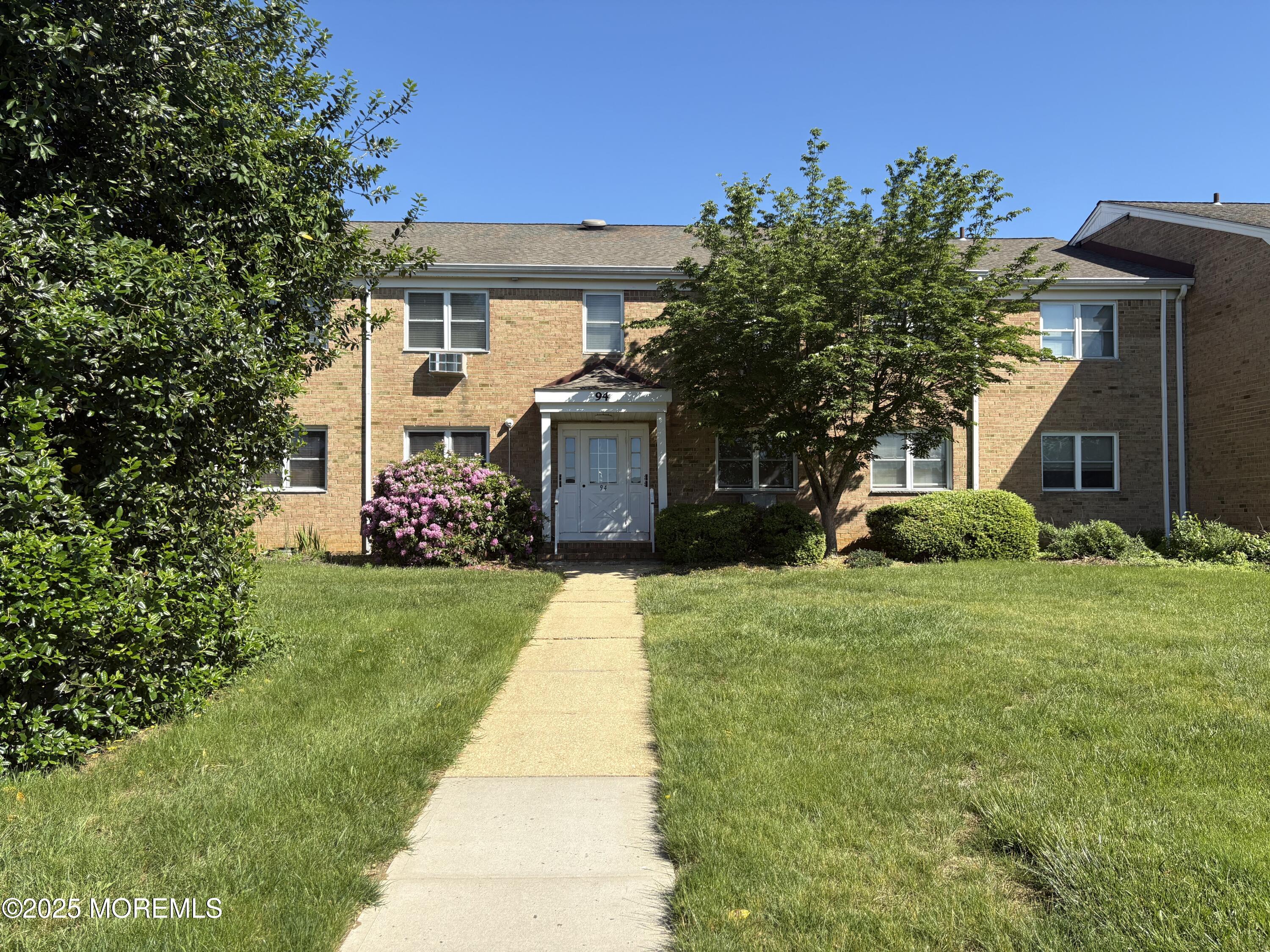 94 Stonehurst Boulevard, Unit E Freehold, NJ 07728 - Photo 11 of 11 a front view of a house with garden