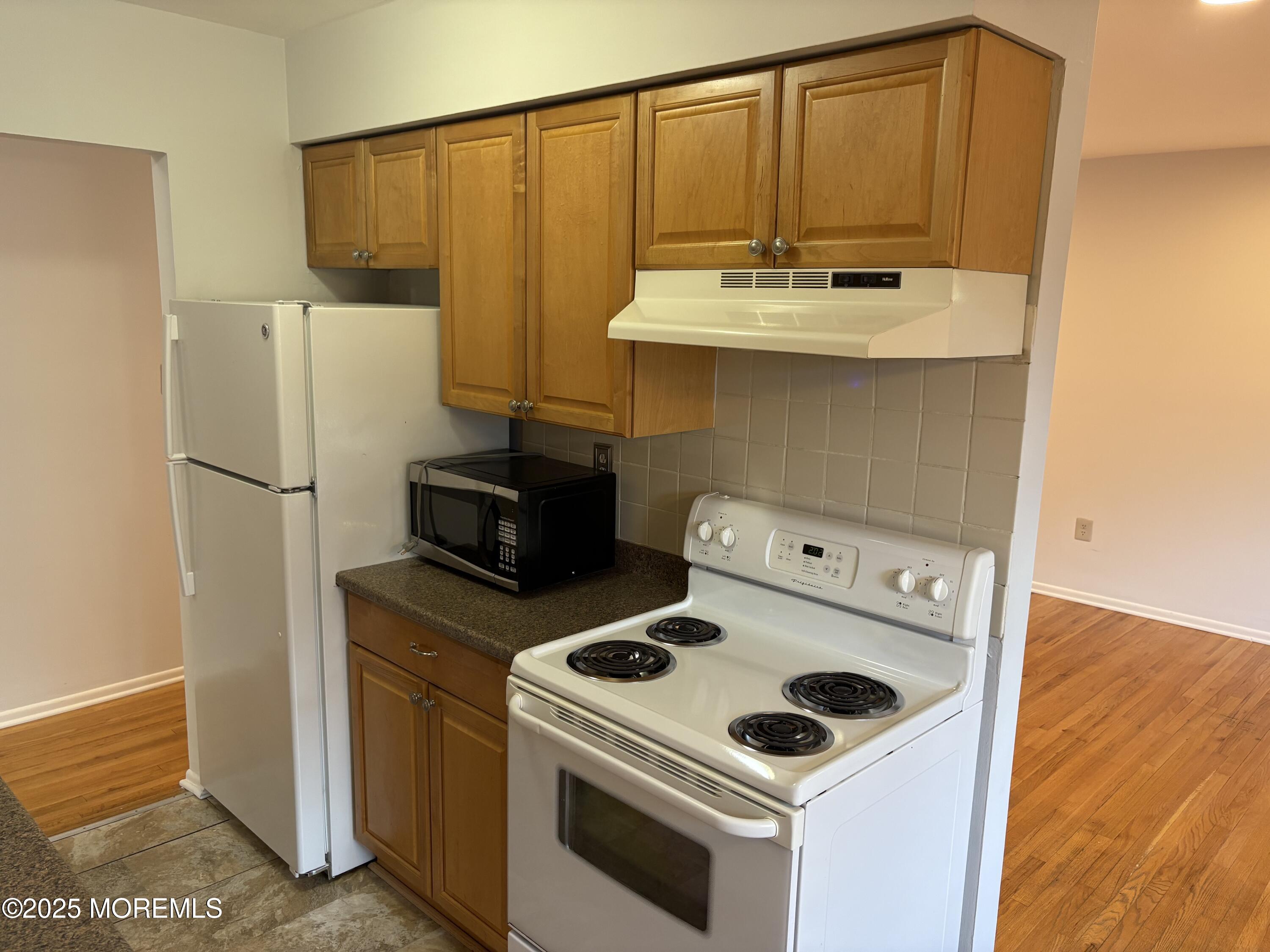 94 Stonehurst Boulevard, Unit E Freehold, NJ 07728 - Photo 4 of 11 a kitchen with a stove and a refrigerator