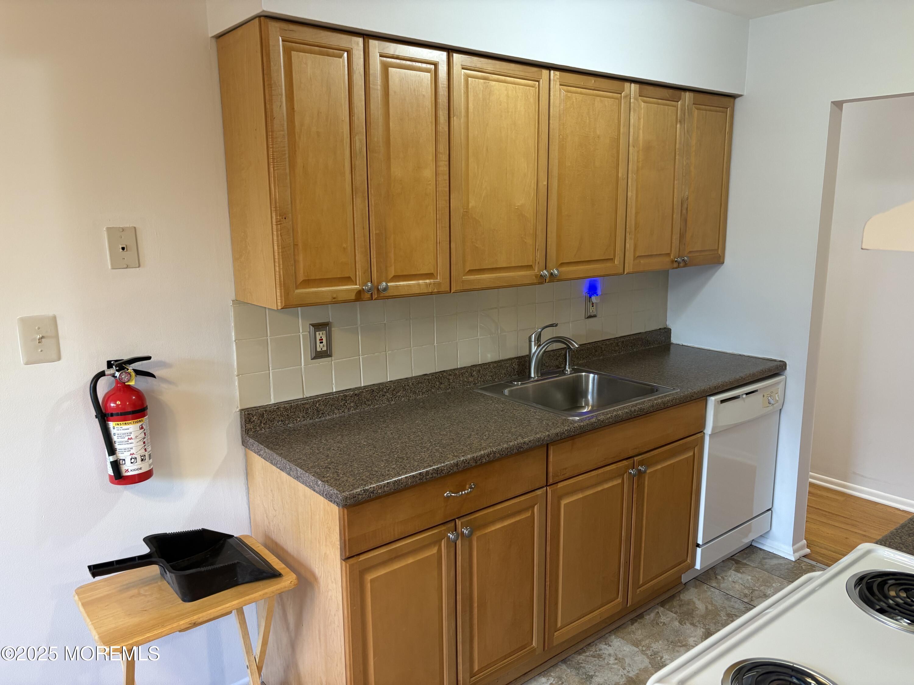 94 Stonehurst Boulevard, Unit E Freehold, NJ 07728 - Photo 5 of 11 a kitchen with stainless steel appliances granite countertop a sink dishwasher stove and cabinets