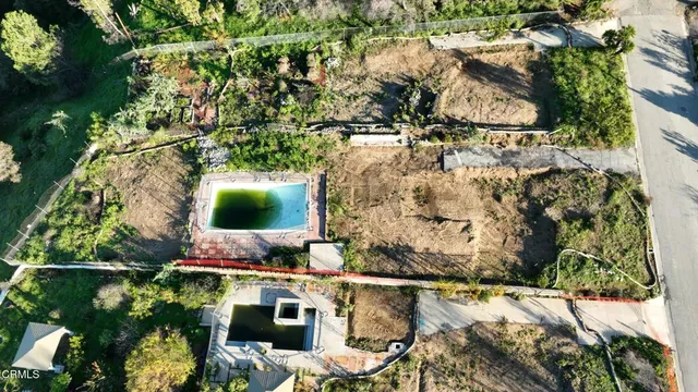 an aerial view of residential houses with outdoor space and trees