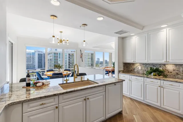 a bathroom with a granite countertop sink a toilet a mirror and shower