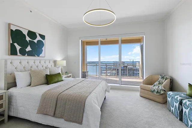 a bedroom with a large bed and a chandelier